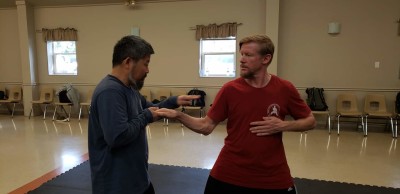 Master Chen showing Rick Pietila how to align the rear elbow with the front hand
